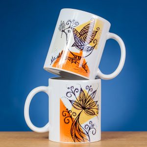 Du dekoruoti paukštelio piešiniu puodeliai sustatyti vienas ant kito